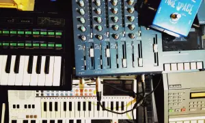 A musician's setup with keyboards, a mixer, and a blue "Time Space" pedal. This image shows how to clear sample data from a synthesizer.