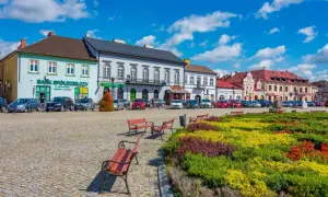 Kolorowy rynek z ławkami i kwitnącymi rabatami, idealne miejsce na tanie wycieczki 3 dniowe.