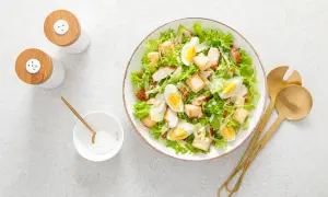 Insalata di pollo sfiziosa con uova sode, crostini e scaglie di parmigiano. Perfetta per un pranzo leggero e gustoso.