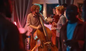 Muzyk z kontrabasem i goście z winem. Idealny strój na koncert jazzowy to swobodna elegancja.