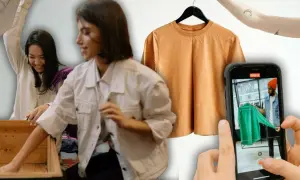 Chicas organizando ropa para vender por internet. Una camiseta naranja cuelga de una percha y un móvil graba a un hombre mostrando una prenda verde.