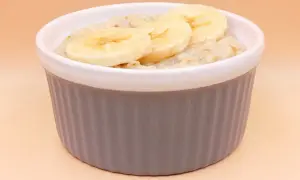 Pyszna owsianka z bananem w szarej miseczce, idealna na zdrowe śniadanie.