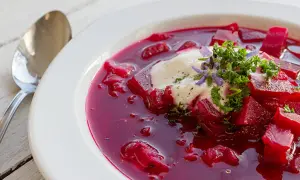 Herzhafte Rote-Bete-Suppe mit einem Klecks Sauerrahm und frischer Petersilie. Ein köstliches Gericht, das an Borretsch Rezepte erinnert.