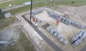 Budowa fundamentów: betonowanie i układanie bloczków przez robotników.
