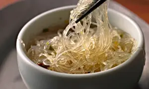 Przezroczysty makaron ryżowy, podniesiony pałeczkami z miseczki. Niska zawartość kcal, idealny na lekki posiłek.