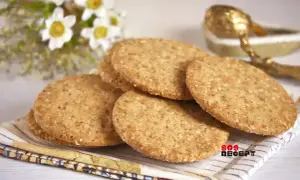 En hög med runda, gyllene digestivekex med sesamfrön. Perfekt för ett enkelt digestivekex recept.