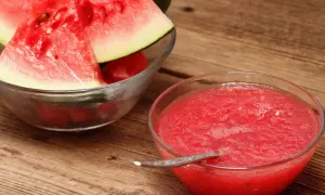 Frische Wassermelonenscheiben in einer Schüssel und eine Schüssel mit leckerer, selbstgemachter Melonen Marmelade.