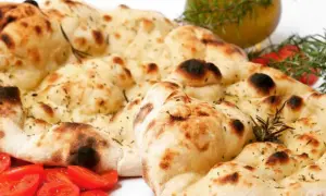 Crescia marchigiana senza strutto, dorata e fragrante, con pomodorini e rosmarino.