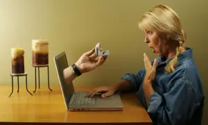 Zaskoczona kobieta otrzymuje pierścionek zaręczynowy przez ekran laptopa. To nowa historia domeny miłości.