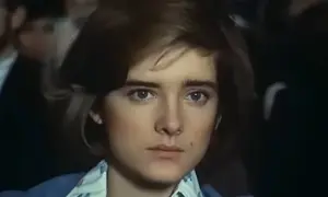 Małgorzata Snopkiewicz dzisiaj, młoda dziewczyna z krótkimi włosami i przenikliwym spojrzeniem, w niebieskiej marynarce.