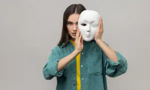 Kobieta z zasłoniętą twarzą białą maską, sugerująca test osobowości paranoicznej.