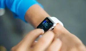 Une personne utilise sa montre connectée pour vérifier des informations. Peut-on téléphoner avec une montre connectée ? Oui, certaines le permettent.
