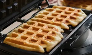 Chrupiące gofry w trakcie pieczenia w gofrownicy. Idealne na śniadanie, zgodnie z naszym przepisem na chrupiące gofry.