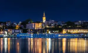 Nocny Belgrad z rzeką i statkiem wycieczkowym. Czy do Serbii potrzebny jest paszport? Sprawdź przed podróżą!