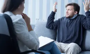Mężczyzna z osobowością histrioniczną w gabinecie terapeuty, gestykuluje i opowiada o swoich problemach.