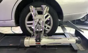 Réglage du parallélisme voiture avec un appareil de mesure sur une roue.