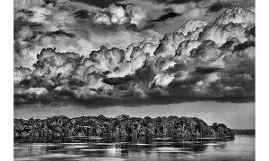 Dramatyczne chmury nad Amazonką, uchwycone przez Sebastiao Salgado. Potężna rzeka i bujna dżungla.