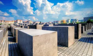 Pomnik Pomordowanych Żydów Europy w Berlinie. Betonowe bloki tworzą labirynt pamięci pod błękitnym niebem.