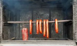 Wędzenie szynki i kiełbasek w wędzarni. Kluczowa jest odpowiednia temperatura, by uzyskać idealny smak.