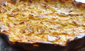Une flognarde aux pommes dorée et appétissante, saupoudrée de sucre glace. Un délice fait maison.