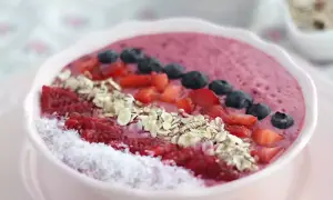 En rosa smoothie bowl med hallon, blåbär, jordgubbar, kokosflingor och granola. En perfekt start på dagen!
