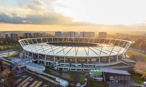 Stadion Śląski w Chorzowie o zachodzie słońca. Obiekt, który gościł niezliczone koncerty, otoczony jest zabudową miejską i zielenią.