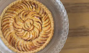 Tarte aux pommes dorée, joliment disposée en spirale. Quelle pâte pour une tarte sucrée ? Une pâte sablée croustillante serait parfaite.