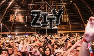 Multitud animada en la entrada del espacio Zity, con brazos en alto y móviles grabando el evento.