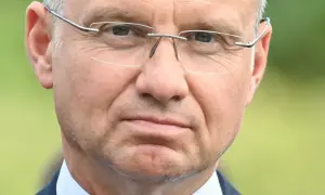 Zbliżenie na twarz mężczyzny w okularach. W jego oczach widać refleksję, jakby zastanawiał się nad przyszłością, może nad swoją emeryturą prezydencką.