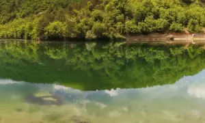 Verde smeraldo del lago di Boccafornace riflette la lussureggiante vegetazione che lo circonda, creando un'immagine speculare mozzafiato.