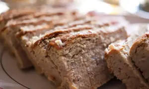 Pokrojony, domowy pasztet z chrupiącą skórką, na talerzu.