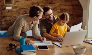 Familj planerar sin ekonomi. Pappa, mamma och dotter vid datorn, diskuterar spartips för hushållsekonomi.