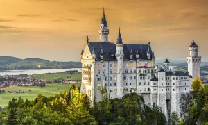 Bajkowy zamek Neuschwanstein, jeden z najpiękniejszych zamków w Europie, wznosi się na skale wśród drzew.