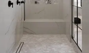 Modern shower with marble-look walls and hexagonal best shower floor tiles. Black fixtures and a built-in bench complete the sleek design.