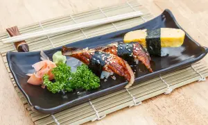 Sushi z węgorzem w sosie unagi. Co to za pyszny sos? Na talerzu też tamago, wasabi i marynowany imbir.