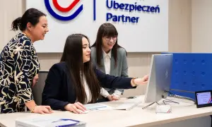 Trzy kobiety przy biurku analizują dane na komputerze.