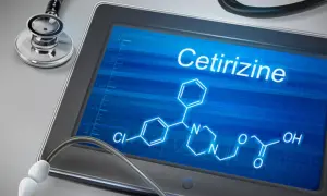 Tablet z ekranem wyświetlającym wzór chemiczny cetyryzyny i stetoskop.