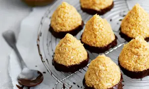 Kokostoppar recept: konfekt med kokos och choklad på ett galler. En sked med choklad ligger bredvid.