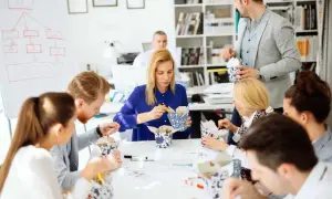 Une équipe profite d'un pause repas, partageant des boîtes de nouilles. Le code du travail permet ces moments de convivialité.