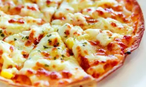 Pyszna, gorąca pizza z patelni, z ciągnącym się serem i ziołami, gotowa do podania.