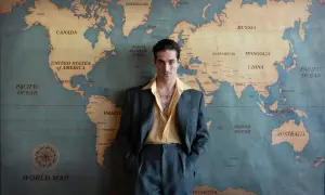 Damiano David w garniturze na tle mapy świata, gotowy na światowy koncert.