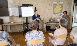 Une conférencière présente une initiation à la généalogie aux archives départementales du Lot.