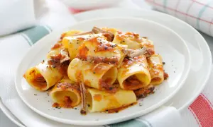 Une assiette de paccheri généreusement nappés d'une sauce tomate riche et de morceaux de viande savoureux. Ce plat de pâtes à la viande est un délice réconfortant.