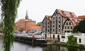 Bydgoszcz: nad Brdą, obok zabytkowych kamienic i ceglanego kościoła, cumuje barka. Nietypowe atrakcje Bydgoszcz czekają!
