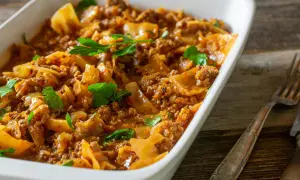 Herzhaftes Schichtkohl mit Hackfleisch, ein beliebtes DDR Rezept, serviert in einer weißen Auflaufform, garniert mit Petersilie.