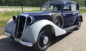 En mörkblå Horsch bil från 1930-talet med reservhjul på sidan.
