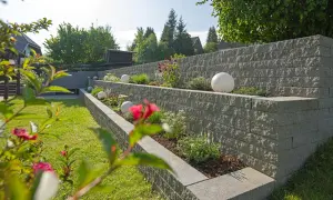 Moderne Gartenmauer mit Terrassierung und dekorativen Kugeln. Tolle Ideen für Gartenmauern, die Struktur und Stil verleihen.