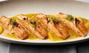 Gebratene Lachsfilets auf einer Zitrussoße, garniert mit Dill und Orangenzesten. Tolle Ideen für eine Fischplatte!