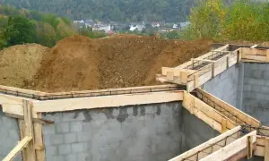 Fundamenty domu w budowie, zbrojenie i szalunki czekają na beton. Widać, ile jest ważne pozwolenie na budowę, by móc rozpocząć taką inwestycję.