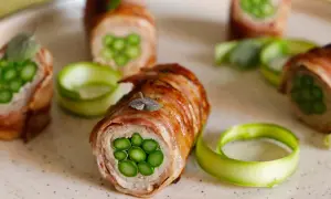 Deliziosi involtini di carne con asparagi freschi, avvolti in pancetta croccante e guarniti con erbe aromatiche.